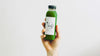 Matcha RTD beverage in plastic bottle held up in front of white background