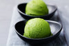 Two scoops of ice cream sit in black bowls as examples of how to use matcha tea
